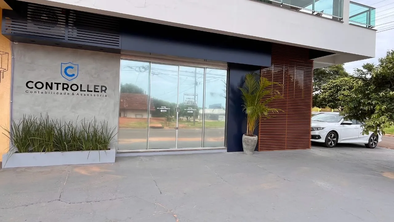Fachada do escritório na Rua Maringá: parede de concreto com o logo da Controller, porta de vidro e ripas de madeira.