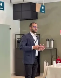 Vitor Rodrigues Dias, de blazer, falando em pé na palestra sobre a Reforma Tributária.